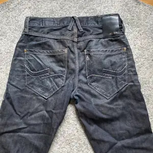 säljer dessa svarta jeans från jack&jones, starkt material, dock lite slitage längs ner på benen, annars väldigt bra kvalité! sitter som bootcut på! storlek: 28/32