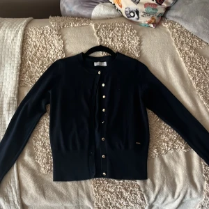 Marinblå kofta med guldiga knappar.  - Jag säljer denna fina marinblåa kofta för att jag tycker att färgen inte passar mig så bra. Koftan är i ett jättebra skick och är inte använd så jättemånga gånger. Materialet är inte så tjockt och inte så jättetunnt. Pris kan diskuteras. 