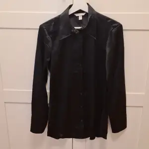 En svart satinskjorta strl XS. Använd en gång. Mycket fin!