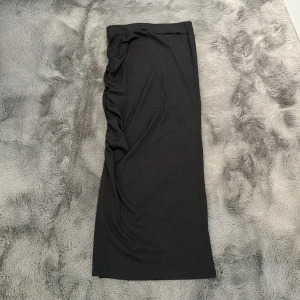 Ribbad Långkjol - Denna långkjol är köpt från hemsidan Shein. Den är ribbad med slits på ena sidan, även med detalj(scrunch) Kjolen är svart i storlek XS