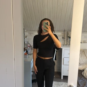 Tshirt med slit - En svart tshirt med fin slit framtill, skönt material. Köptes på Gina tricot i storlek S