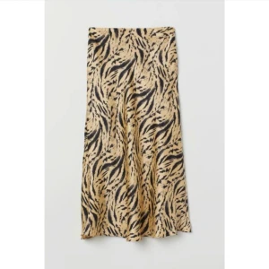 H&M Trend kjol i satin midikjol lyocell viskos 36 nyskick slutsåld gul svart - Säljer en kjol i satin från H&M. Storlek: 36 Skick: oanvänd i nyskick, lite skrynklig för tillfället då den legat i en påse med sommarkläder.  Material: 69% lyocell, 31% viskos