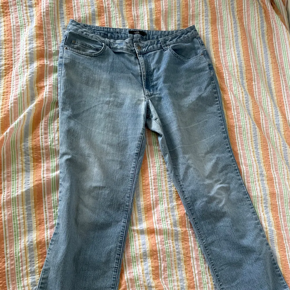 Ett par ljusblå jeansbyxor från märket Isolde. Byxorna har en klassisk femficksdesign med knapp och dragkedja framtill. Baktill finns två fickor med dekorativa sömmar.. Jeans & Byxor.