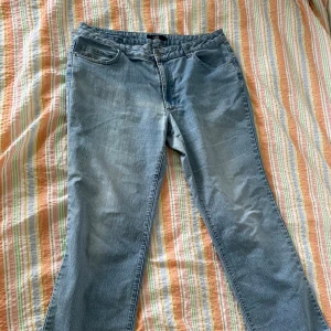 Ljusblå jeansbyxor från Isolde - Ett par ljusblå jeansbyxor från märket Isolde. Byxorna har en klassisk femficksdesign med knapp och dragkedja framtill. Baktill finns två fickor med dekorativa sömmar.