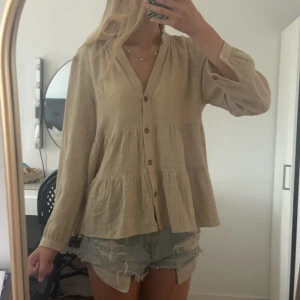 Zara blus - Super söt somrig blus, den är beige med en varmare ton, så skön och har knappar sånger att kläpps upp och ändra V ringningen💗 ny pris 399kr köpte för runt 1 år sedan 💗💗