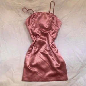 Klänning  - Vintage klänning i en vacker rose gold färg. Klänningen har tunna axelband och en figursydd passform. 