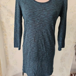 Mörkblå klänning från H&M - En mörkblå klänning från H&M med långärmad design. Klänningen har en rund halsringning och är tillverkad i ett mjukt och bekvämt material.