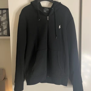 Ralph lauren zip hoodie - Skitsnygg Ralph lauren zip! Har svårt att avgöra färgen men antingen väldigt väldigt mörkblå eller svart, vitt märke 😁