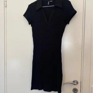 Klänning  - En kort klänning med krage i storlek S