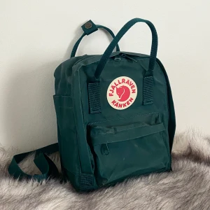 Kånken Mini Arctic Green - Äkta Fjällräven Kånken Mini i färgen ”Arctic Green” <3 Väskan har använts 2 gånger så den är i superbra skick! Sittdyna medföljer.