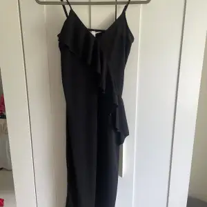 Super söt svart långklänning med volang, passar perfekt nu till sommaren! 