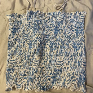 Topp - En väldigt stretchig topp i storlek S. Den är zebra mönstrad i färgen blå och vit.