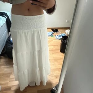 Vit långkjol - Säljer min oanvända vita långkjol som är köpt iår! Säljer då jag inte är så förtjust i den långa midjan med smock, då det tyvärr inte passade mig så bra. Kjolen är superbra kvalitet och är inte genomskinlig! Tveka inte att kontakta vid frågor!💕