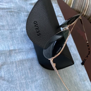 Nästan oanvänd original GUESS solglasögon  - Hej Nästan oanvänd GUESS solglasögon utan anmärkning komplett med original fodral samt putsduk 