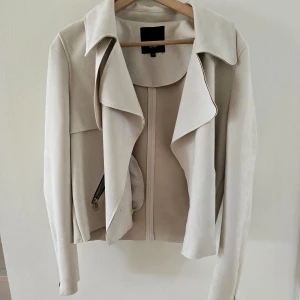 Tunn jacka från River Island  - Storlek 40 (12 UK size). Beige/creme färgad, mocka-material. 