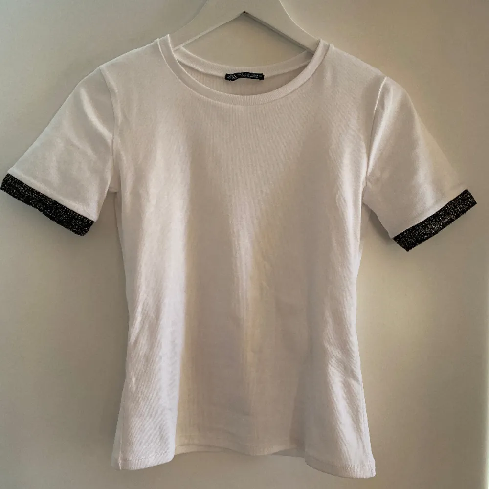 Säljer denna T-shirt med detaljer på ärmarna från Zara💗Passar perfekt till vardags och är ett fint basplagg. Storlek S. Köparen står för frakt💕. T-shirts.