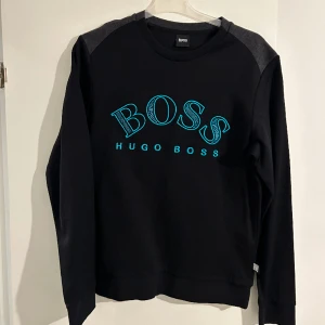 Hugo boss tröja - Hugo boss tröja Storlek M  Använd 2-3 gånger Svart och neon blå Nyskick  Pris kan diskuteras vid snabb affär