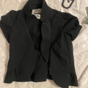 Bolero med glitter  - En jätte söt bolero med pärlor som detaljer och små volanger, tyvärr lite för liten för mig! 