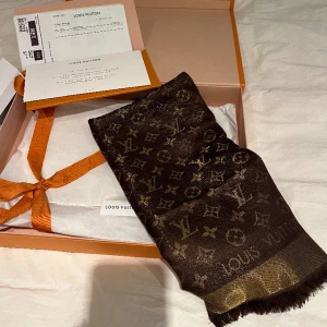 Brun Louis Vuitton sjal  - En såå fin brun Louis Vuitton sjal med lite guld i! Köpte till mamma men blev fel färg… så den är helt oanvänd! Originalkvitto, dustbag och låda ingår! Storlek, 142x142  Köpt för 6 850kr! Ni får gärna komma med bud!   Endast seriösa köpare 💕🥰