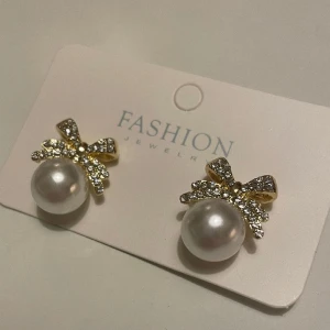 Örhängen med strass - Fina nya örhängen med strasstenar. Mått ca 1,9x1,7 cm.