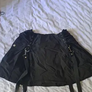 Used item but still in very good condition. Straps on each side and string to loosen or tighten skirt. Zipper in the back 