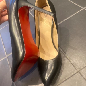 Svarta klackar med röd undersula - Supersnygga klackskor med spetsig tå och röd undersula, (säljer ett par likadana för billigare pris som är mer slitna i profilen). Säljer då de är för stora på mig, storlek 41