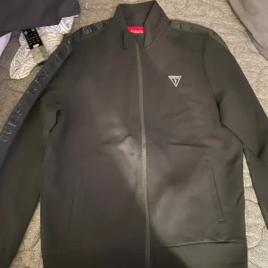 Guess tracksuit  - Använt tracksuiten en gång bra skick. fortfarande som ny köpt på Barkarby outlet storlek på byxorna är S och överdelen M