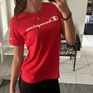 T-shirt - Helt ny topp från champion. Sitter löst på mig i storlek S. Små champion märken i texten på framsidan. Fin röd färg.💥