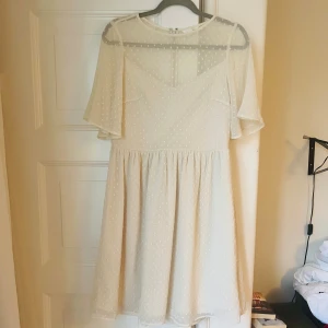 Benvit sommarklänning från h&m - Benvit knälång sommarklänning från h&m. Finns några små fläckar på ryggen - se bild. Köparen står för eventuell frakt.