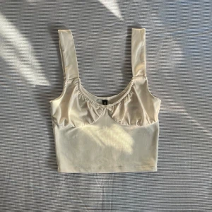 Vitt linne med rosett - Super gulligt linne från H&M med rosett och räfflade kupor. Axelbanden är breda och tyget är bekvämt. Fint skick. Skriv gärna till mig om du har frågor eller vill se fler bilder!<3