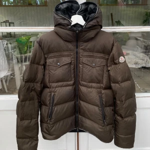 Moncler Thomas Giubotto Puffer - Hej, säljer en ursnygg Moncler Thomas jacka i brun färg. Välanvänd med defekter, bild i DM! Nypris över 8000kr. Avtagbara ärmar & luva. Storlek 3 vilket motsvarar Medium. Enormt snygg modell. Passar till allt. Pris kan diskuteras. Hörs i DM! 