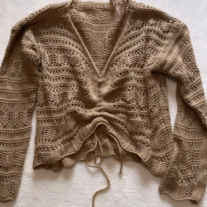 Stickadtröja XS-S NYTT - Snygg stickad tröja att ha nu till sommaren. Snörning fram som kan justeras beroende på hur mycket man vill visa magen.   Nyskick  Storlek XS-S