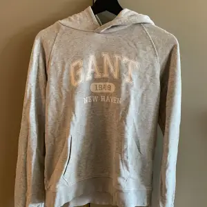 En grå Gant hoodie som passar kanske strl XS. Strl 170 i tröjan. 