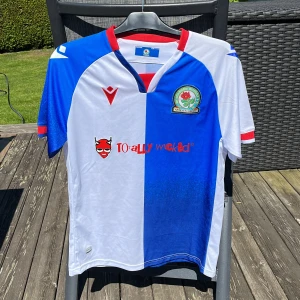 Blackburn Rovers 22/23 Fotbollströja - Säljer min Blackburn fotbollströja från 22/23, då den aldrig används och inte heller använts (förutom att den testats såklart). Inte original! Storlek: M Skick: 10/10 (ny)