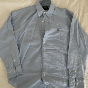 Ralph Lauren skjorta - Ljusblå Ralph lauren skjorta i mycket bra skick och sparsamt använd. Säljer den eftersom den har blivit för liten för mig. Kan också stryka den för den som vill. Pris kan diskuteras.