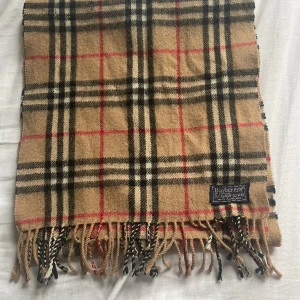 Burberry halsduk - Säljer min feta burberryhalsduk som är 50% cash 50% wool, givetsvis äkta. Skicket på halsduken är 8/10, vid fler frågor eller funderingar är de bara att höra av sig!