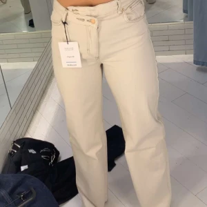 Pull&Bear jeans - Beiga jeans från Pull&Bear med asymmetrisk knäppning/överlappning i fram. Använda endast 1 gång och köpta för 400kr men säljer för 150kr!💕