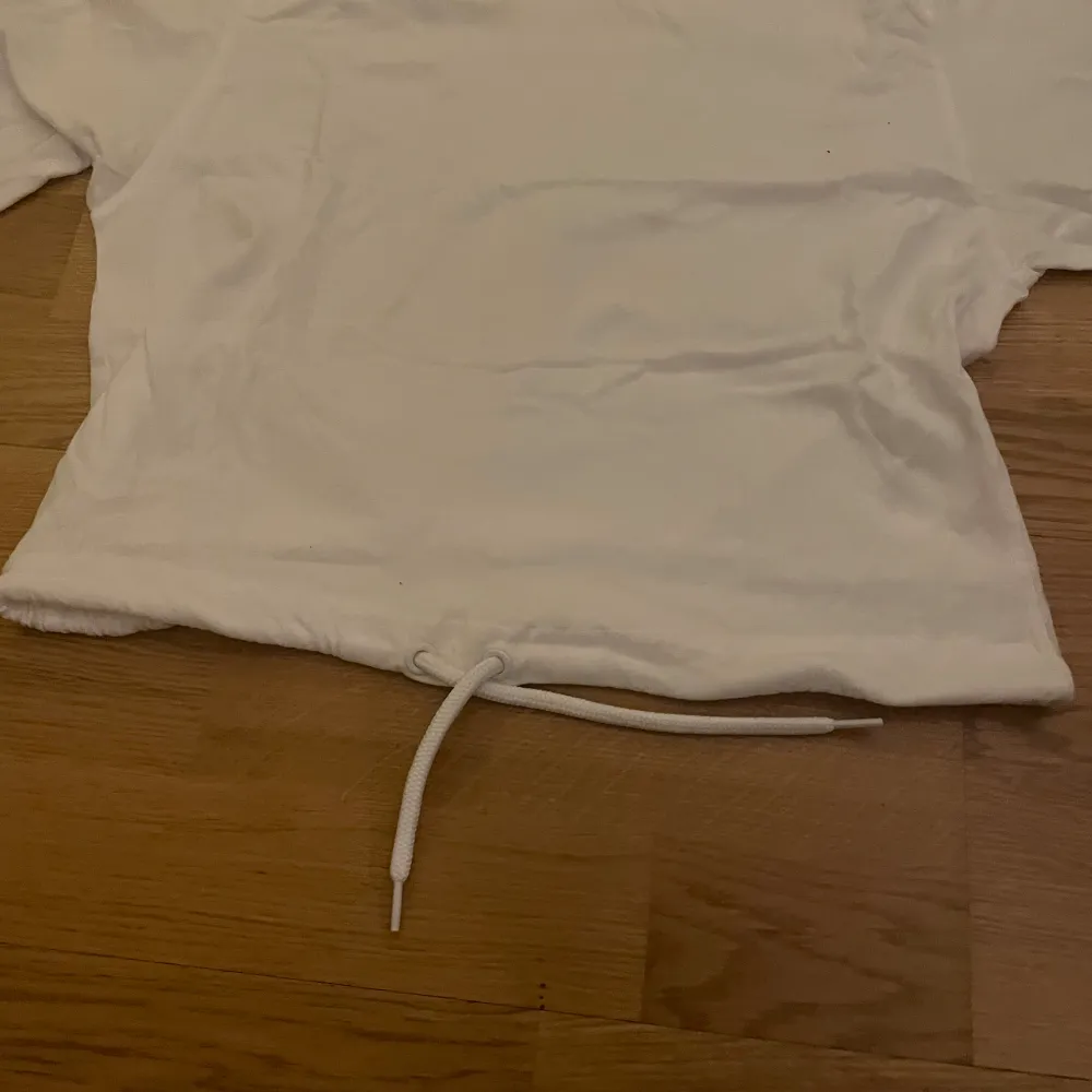 en croppad t-shirt från monki. tröjan har ett snöre som använda för att knyta tröjan. nästan helt oanvänd förutom på en skolavslutning. storlek XS, men kan även passa någon med S. om ni har några frågor får ni gärna höra av er! :). T-shirts.