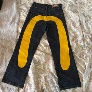 Evisu jeans - Säljer dessa Evisu jeans som är äkta eftersom de inte blir använda längre. De är i bra skick förutom lite slitningar på den gula färgen! Sitter snyggt och köpta här på Plick för något år sedan. Skriv vid frågor!