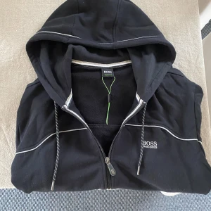 Hugo boss hoodie - Säljer denna hugo boss hoodie då den ej används, den är använd 1 gång och sedan har den bar legat. Hör av dig om du har frågor eller vill ha mer bilder
