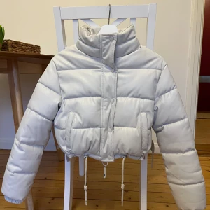 Dunjacka croppad - Croppad dunjacka i ljus greige från Bershka. 