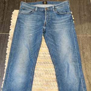 Snygg jeans från Lee i modellen Daren, fint skick, finns en slitning på låret men den gör dom mer unika, storlek W32 L32
