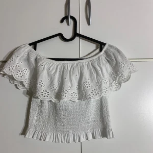 Vit sommartopp  - En vit topp perfekt till sommaren. Man kan ha den på olika sätt. Köpt i Italien för 300kr. Står ingen storlek på toppen men skulle säga att den är ungefär xs-s då den är stretchig. Använd en gång så ny skick. Pris kan diskuteras!