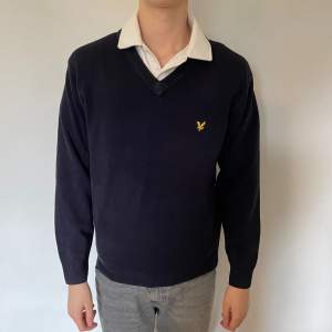 Blå långärmad tröja från Lyle & Scott. Kragen är V-skuren och den är i storlek S. I bra skick.  