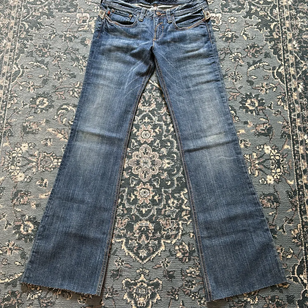 Säljer nu mina älskade vintage low rise bootcutjeans med skitsnygga stjärnor på fickorna vilket gör hela jeansen 🤩 Från 2000-talet! OBS; Jeansen är avklippta längst ner. Midjemåttet tvärsöver: 37 cm. Innerbenslängd: 80 cm. ⭐️💘. Jeans & Byxor.