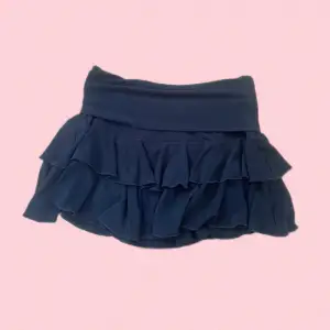 Kort svart kjol med volanger. Man viker ner midjan vilket gör att man själv kan bestämma längd på kjolen! Kjolen är i bra skick🩷dm för frågor eller fler foton!