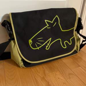 En limegrön och svart maloperro väska med en hund på. Jättesnygg men används knappt, inga defekter !!! Messenger bag / datorväska / axelremsväska.  Kan diskutera priset så hör bara av dig🫶