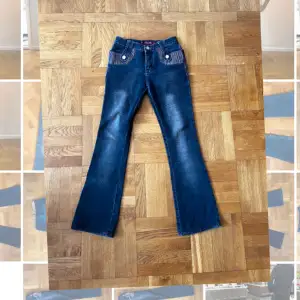 Lågmidjade utsvängda jeans  med detaljer
