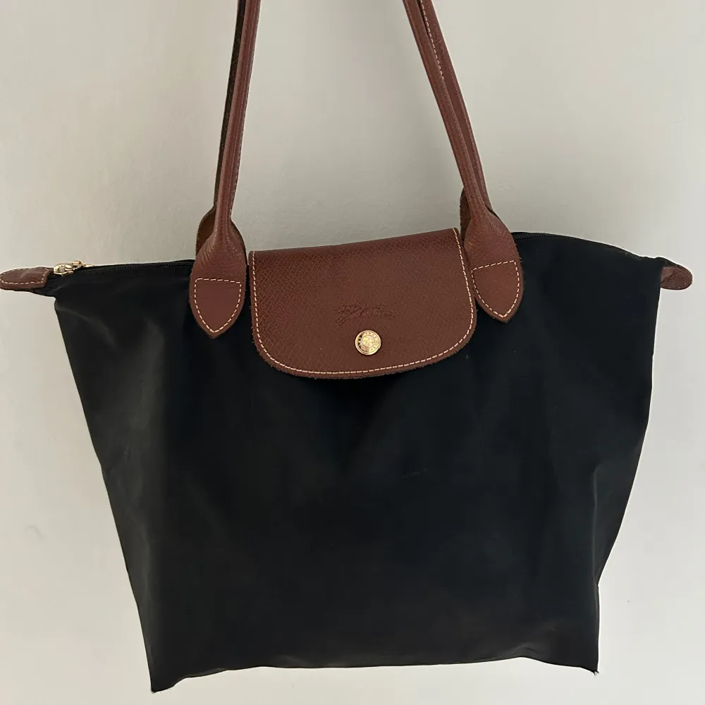 Superfin svart Longchamp väska med bruna detaljer, använd fåtal gånger. 🥰  Nypris: 1299kr. Väskor.