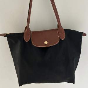 Superfin svart Longchamp väska med bruna detaljer, använd fåtal gånger. 🥰  Nypris: 1299kr